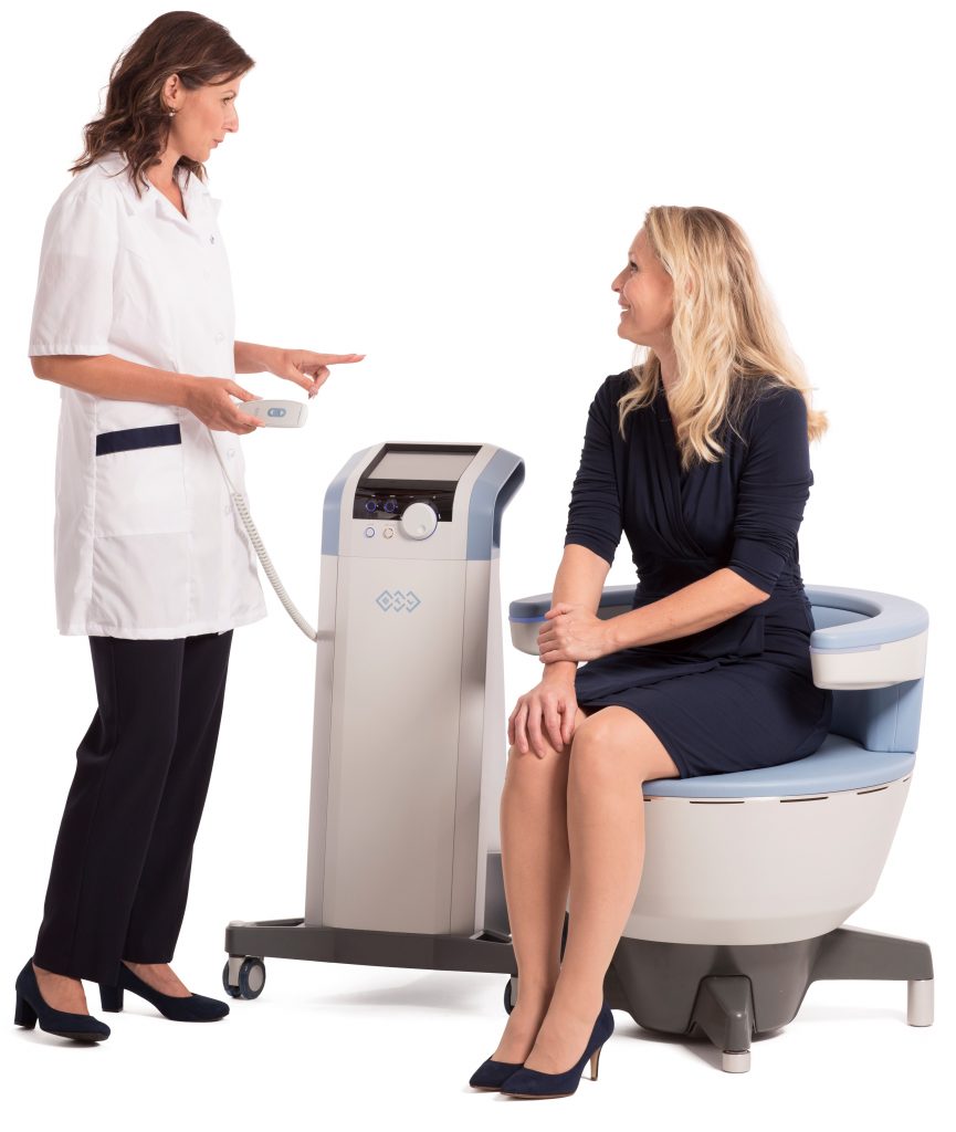 Doctor standing with Emsella equipment speaking to seated patient
